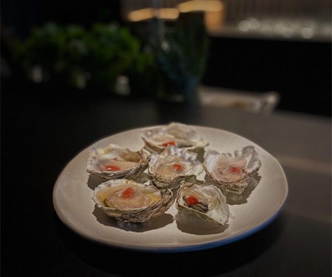 Grilled Sumo Kumo Oysters with Yuzu Koshō and Lardo from local pigs at TOMO Seattle
