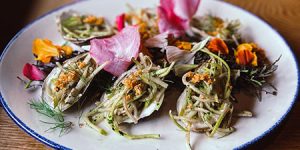 Healthy grilled oysters with kohlrabi slaw and fresh herbs and edible flowers from the garden at Sylvan Table in Sylvan, MI